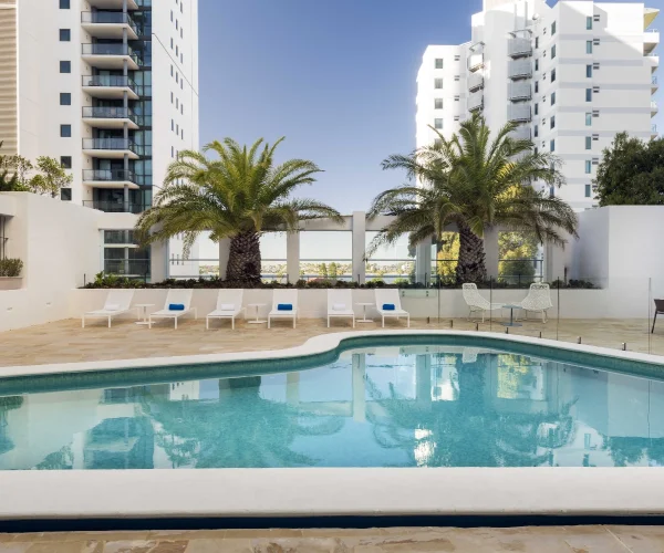 Hotel pool area in Perth before composite decking installation showing outdated poolside layout prior to upgrade by Your Trade Solutions